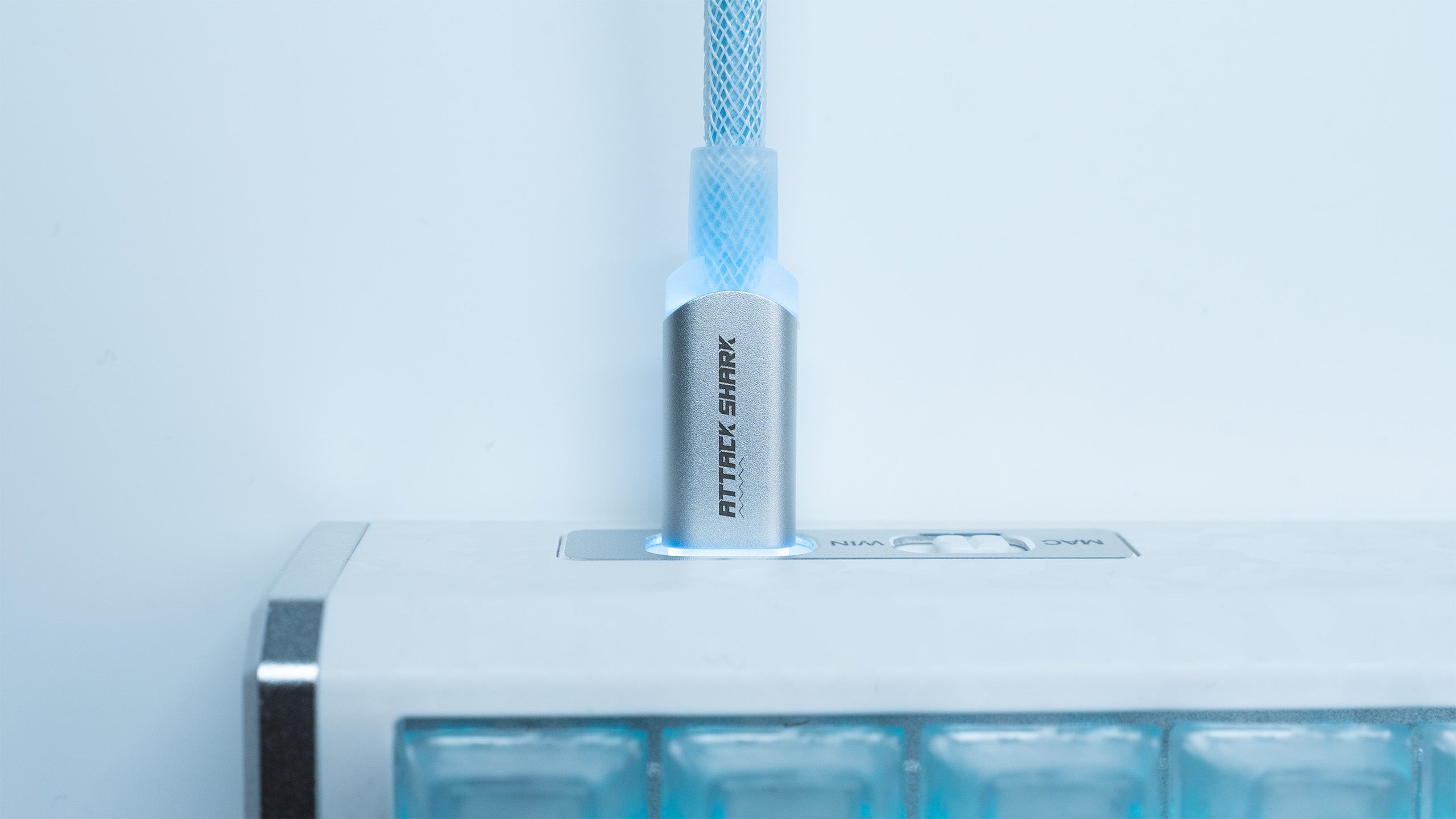 ATTACK SHARK C01ULTIMATE coiled USB-C cable connected to a keyboard, silver connector with blue glow